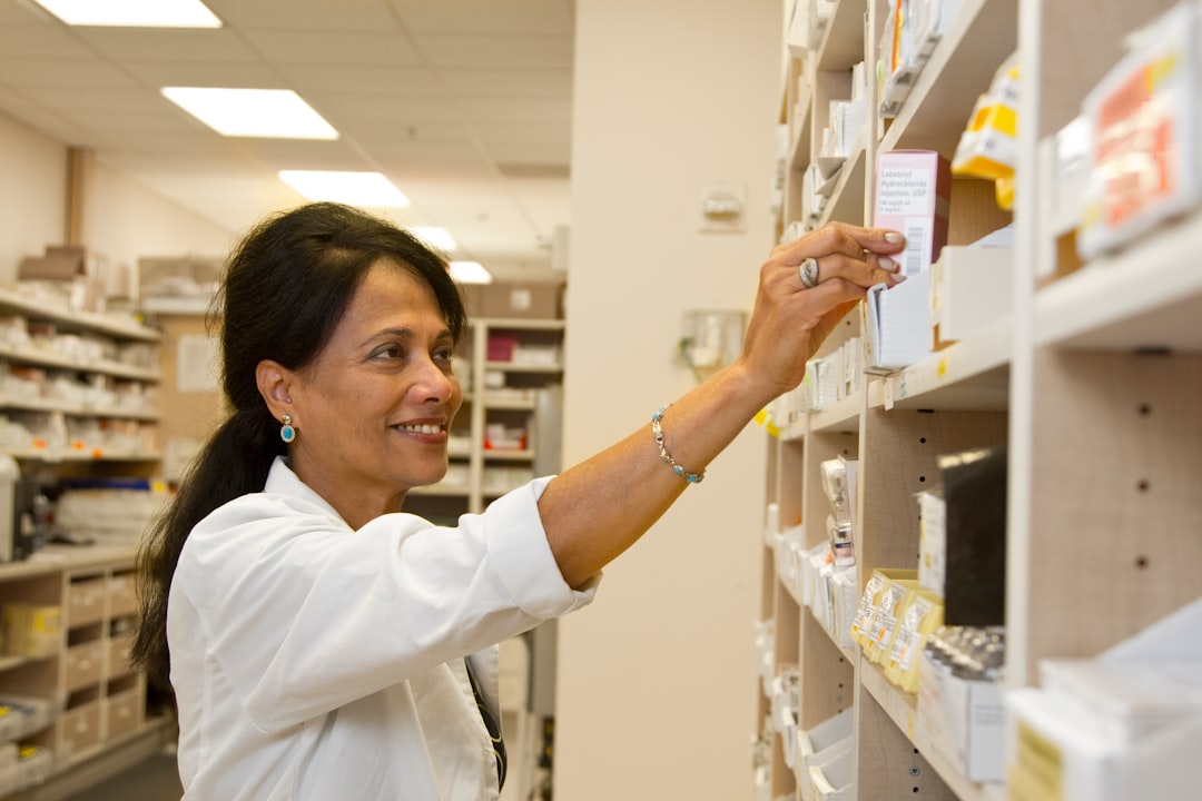 Pharmacist selecting medicine from a pharmacy shelf